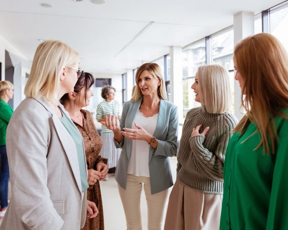 Eine Gruppe von Frauen unterhält sich während einer Pause bei einer Veranstaltung zum Thema Frauen in Führungspositionen.
