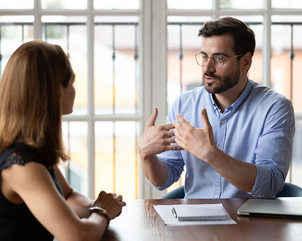Ein Sparkassenfachwirt führt eine Privatkundenberatung mit einer Kundin