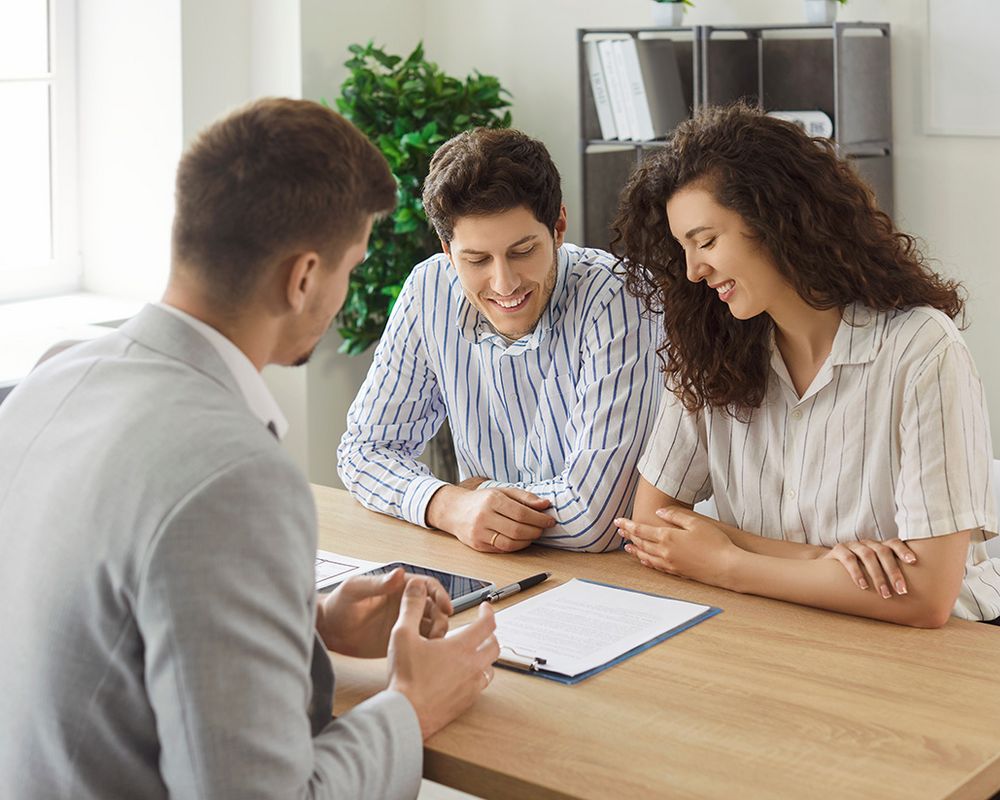 Ein junger Bankberater wendet sein neu erlangtes Wissen aus der Weiterbildung zum Sparkassenfachwirt für Kundenberatung in einem Beratungsgespräch an