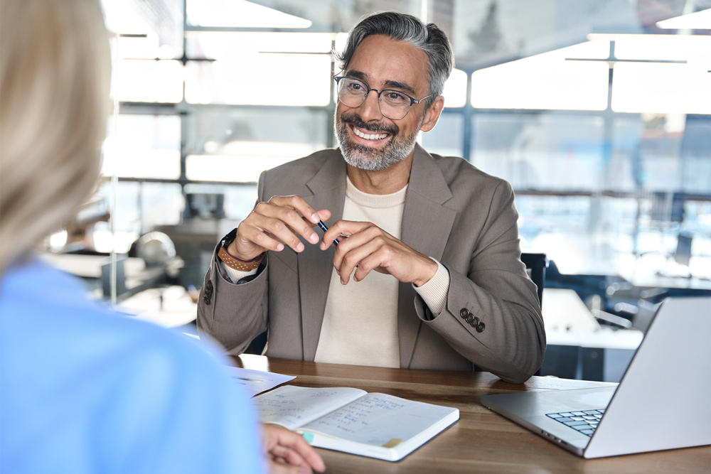 Ein Kundenberater berät eine Kundin im Kundengespräch zu verschiedenen Kontomodellen.